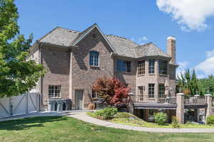 Back of property featuring a lawn and a balcony