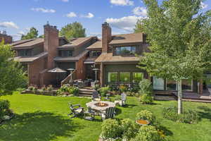 Rear view of house featuring an outdoor fire pit, a yard, and a wooden deck