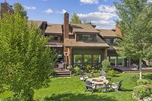 Back of house featuring a yard, a fire pit, and a deck