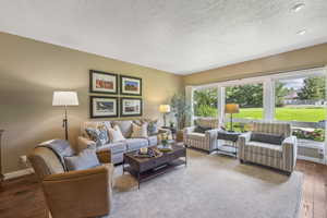 Living room with a textured ceiling and hardwood / wood-style flooring