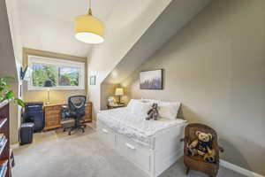 Bedroom featuring vaulted ceiling and light colored carpet