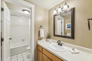 Full bathroom with shower / bath combo with shower curtain, tile patterned flooring, toilet, and vanity