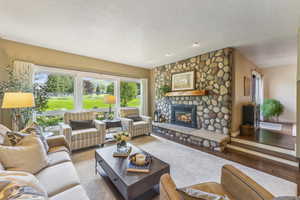 Living room featuring a fireplace, light hardwood / wood-style floors, and a textured ceiling