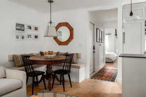 Dining room with crown molding and light wood-type flooring