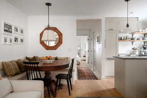 Dining area featuring light hardwood / wood-style floors and ornamental molding