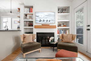 Living area featuring built in features, wood-type flooring, and sink