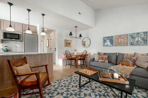 Living room featuring high vaulted ceiling and light hardwood / wood-style flooring