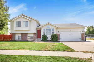 Tri-level home with a garage and a front lawn