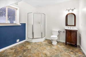 Bathroom with a shower with shower door, toilet, and vanity