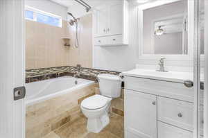 Full bathroom with tile patterned flooring, toilet, shower with separate bathtub, ceiling fan, and vanity