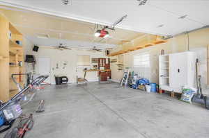 Garage featuring ceiling fan and a garage door opener