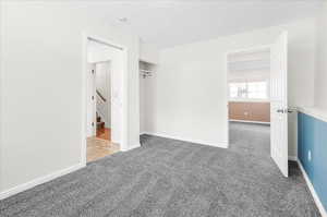 Carpeted spare room with a textured ceiling