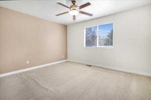 Carpeted spare room with ceiling fan