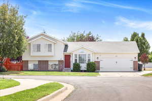 Split level home with a garage and a front yard