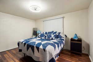 Bedroom with dark hardwood / wood-style flooring