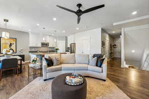 Living room featuring ceiling fan, sink, and wood-type flooring