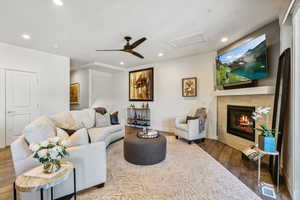 Living room featuring a fireplace, dark hardwood / wood-style flooring, and ceiling fan