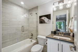 Full bathroom with shower / bath combination with glass door, vanity, toilet, and a textured ceiling