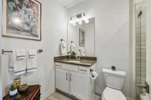 Bathroom featuring vanity, toilet, wood-type flooring, and a shower with door