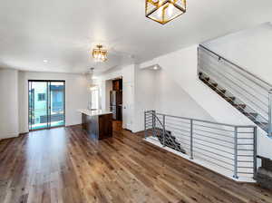 Unfurnished living room featuring sink, hardwood / wood-style flooring, and a notable chandelier