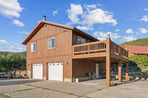 View of home's exterior with a garage and a deck