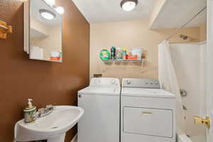 Laundry room featuring sink and separate washer and dryer