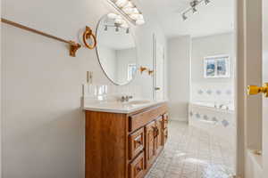 Bathroom with tiled tub and vanity