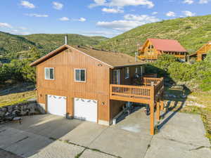 View of home's exterior with a garage and a deck with mountain view