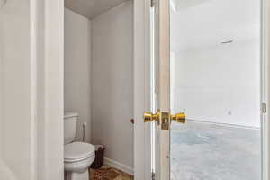 Bathroom featuring toilet and concrete flooring