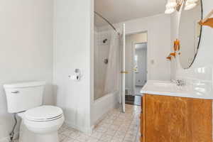 Full bathroom with vanity, tile patterned flooring, toilet, and shower / bath combo