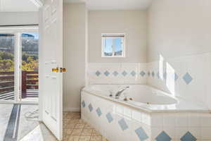 Bathroom with tile patterned floors and a relaxing tiled tub