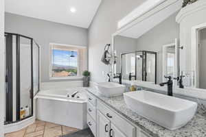 Bathroom with vanity, vaulted ceiling, and shower with separate bathtub