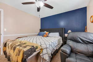 Bedroom with ceiling fan, carpet floors, and vaulted ceiling