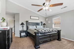 Carpeted bedroom with ceiling fan, crown molding, and vaulted ceiling