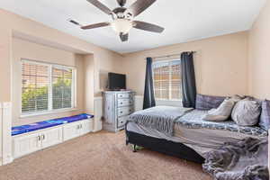 Bedroom with ceiling fan and light carpet