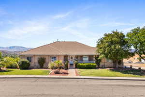 View of front of home with a mountain view and a front lawn