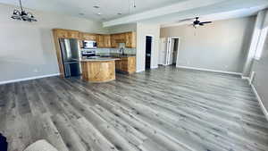 Kitchen featuring hanging light fixtures, stainless steel appliances, light wood-type flooring, and a kitchen island