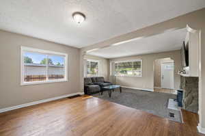 Living room with a textured ceiling and wood-type flooring