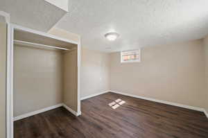 Basement featuring dark wood-type flooring and a textured ceiling