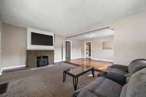 Living room featuring a fireplace, a textured ceiling, and hardwood / wood-style floors