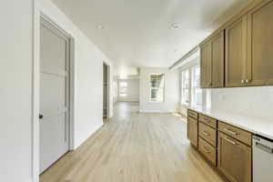 Kitchen with light wood-type flooring, backsplash, and dishwasher. 2411 S.