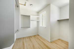 Owner's Walk-in closet with light hardwood / wood-style flooring. 2425 S.