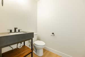 Main Floor Bathroom featuring toilet and wood-type flooring. 2411 S.