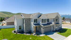 View of front of property featuring a mountain view, a garage, and a front lawn