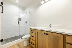 Bathroom featuring vanity, toilet, wood-type flooring, and walk-in shower. 2411 S.