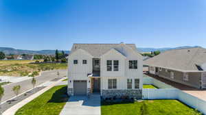 View of front facade featuring a mountain view, a garage, a front lawn, and central AC. 2425 S.