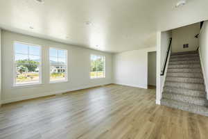 Living room with a wealth of natural light, light hardwood / wood-style flooring, and a textured.  ceiling. 2425 S.