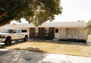 Ranch-style home featuring a front lawn