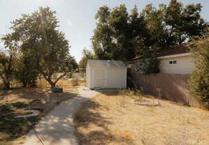 View of yard featuring an outdoor fire pit and a storage shed