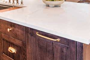 Interior details featuring dark brown cabinetry and light stone countertops